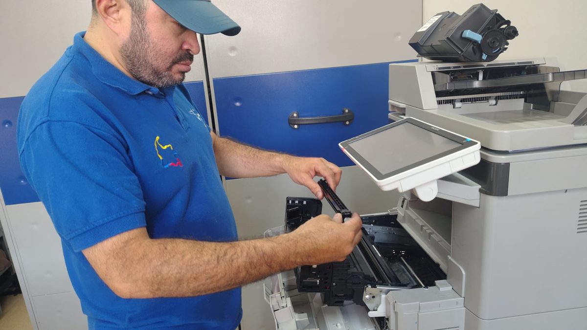 Técnico retirando una pieza interna de una fotocopiadora Ricoh para limpiar el recorrido del papel y corregir las rayas y manchas en la impresión