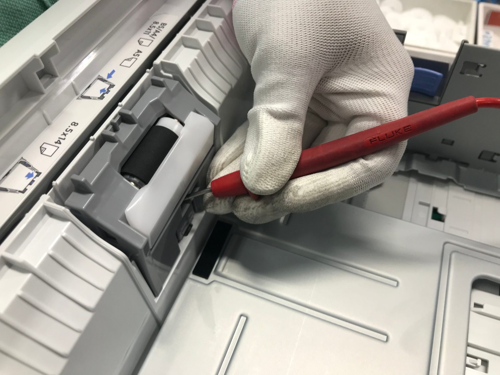 Técnico reparando el sistema de alimentación de papel de una fotocopiadora