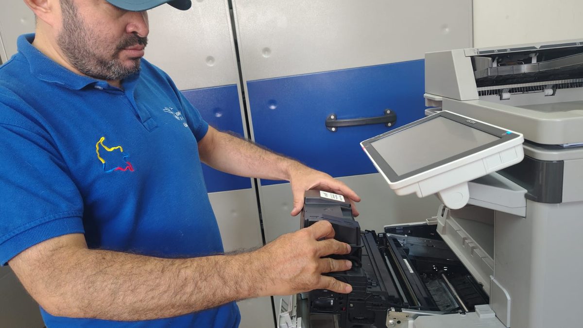 Técnico de EDAYCOPY Digital cambiando el tóner de una fotocopiadora Ricoh durante una visita de mantenimiento en Medellín